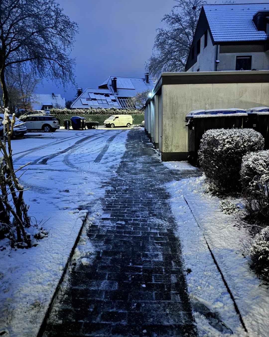 Geräumter Gehweg im Schnee am Abend